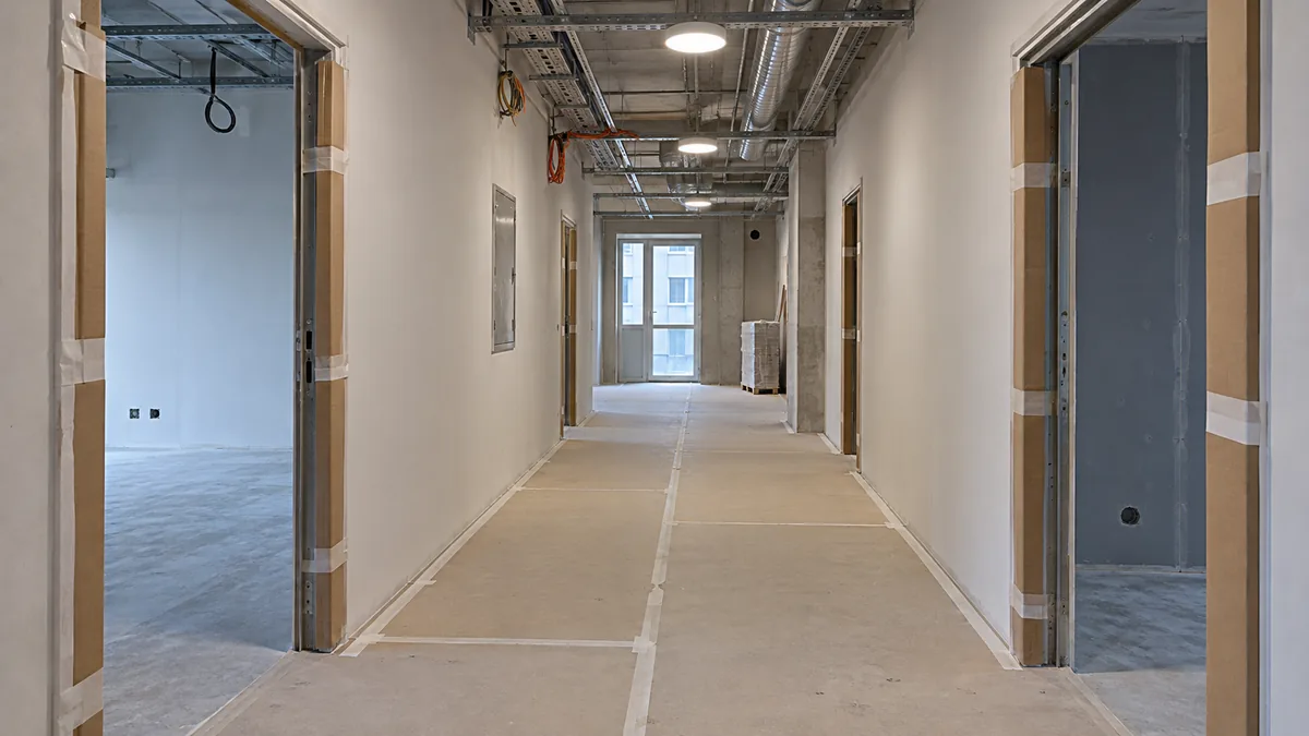 A corridor in a technical building with protected flooring and door frames.